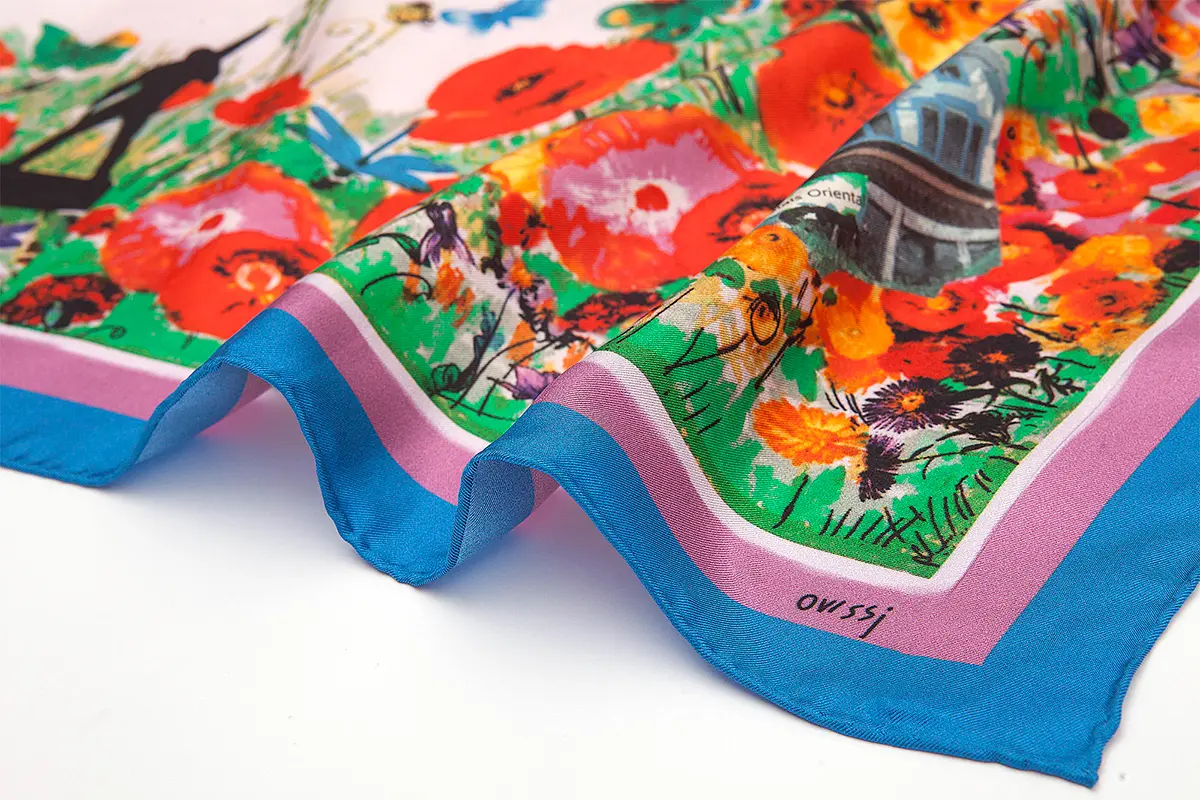 Close-up of a colorful floral-print silk scarf with a blue border