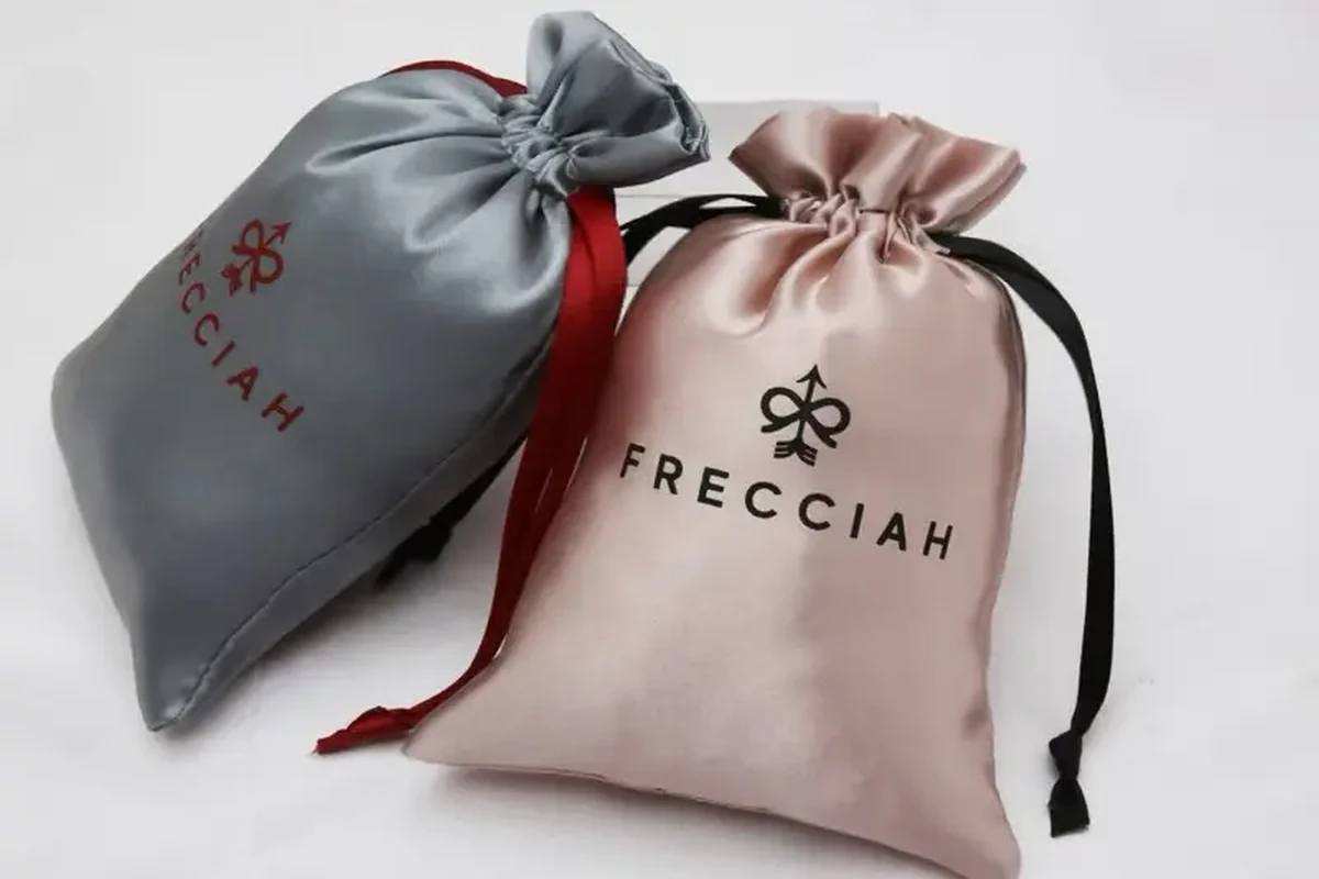 Printed custom logos on gray and pink silk drawstring pouches