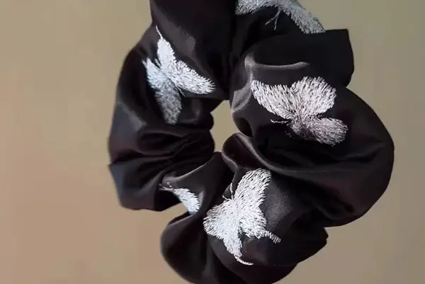 Embroidered logo detail on silk fabric