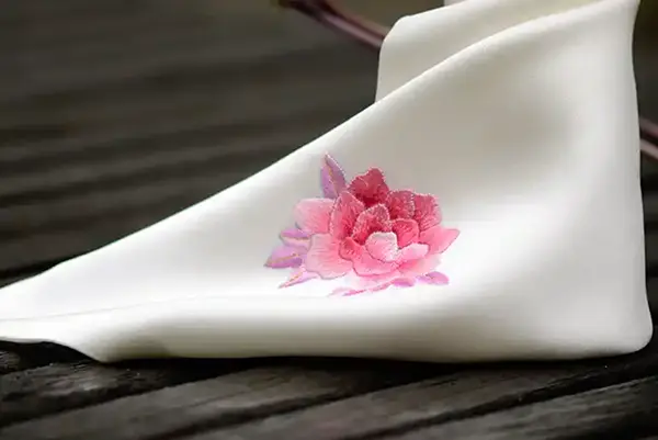 embroidered logo detail on silk shawls