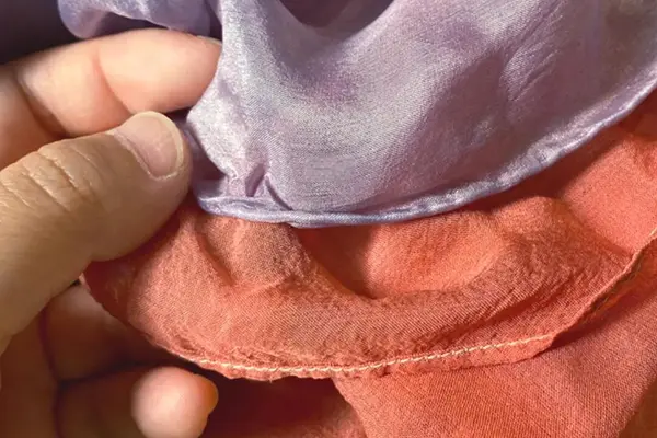 Hand-rolled and stitched edges on luxury silk scarf