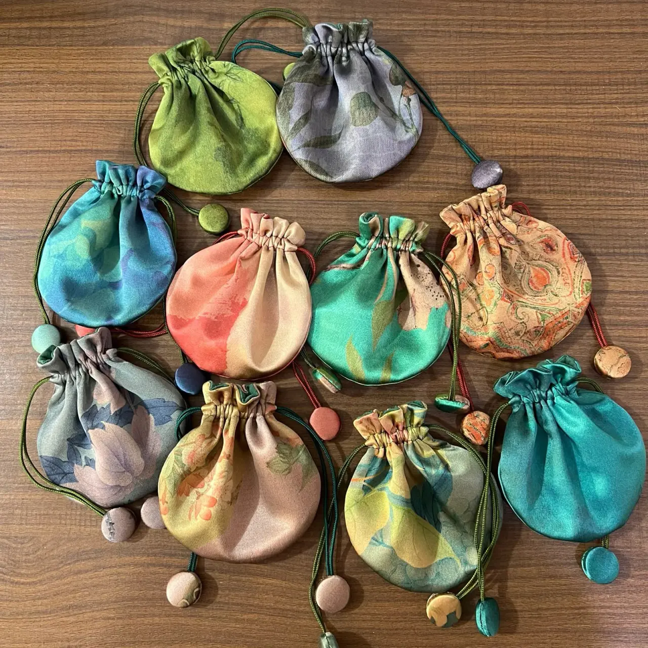 Printed round silk jewelry pouches with fabric-covered cord ends