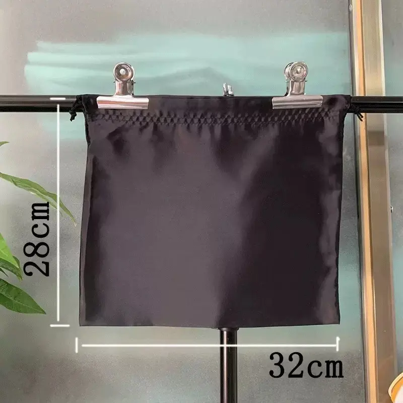 Black satin dust bag measuring 32 by 28 centimeters