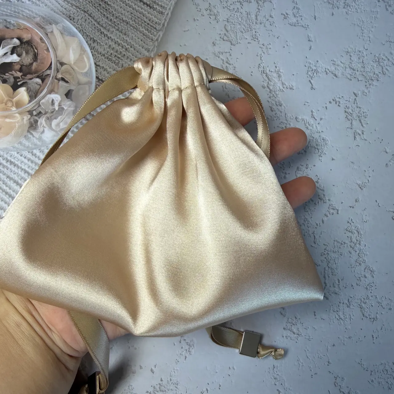 Champagne satin gift pouch with ribbon drawstrings and metal cord ends